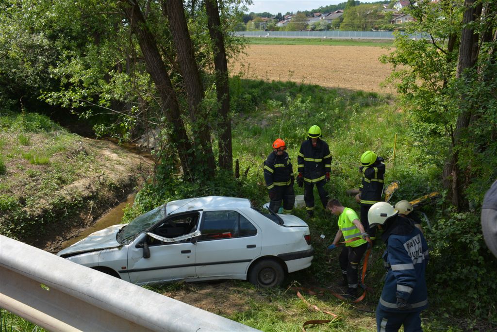 FOTO: Zapeljala s cestišča in se prevrnila na streho v potok